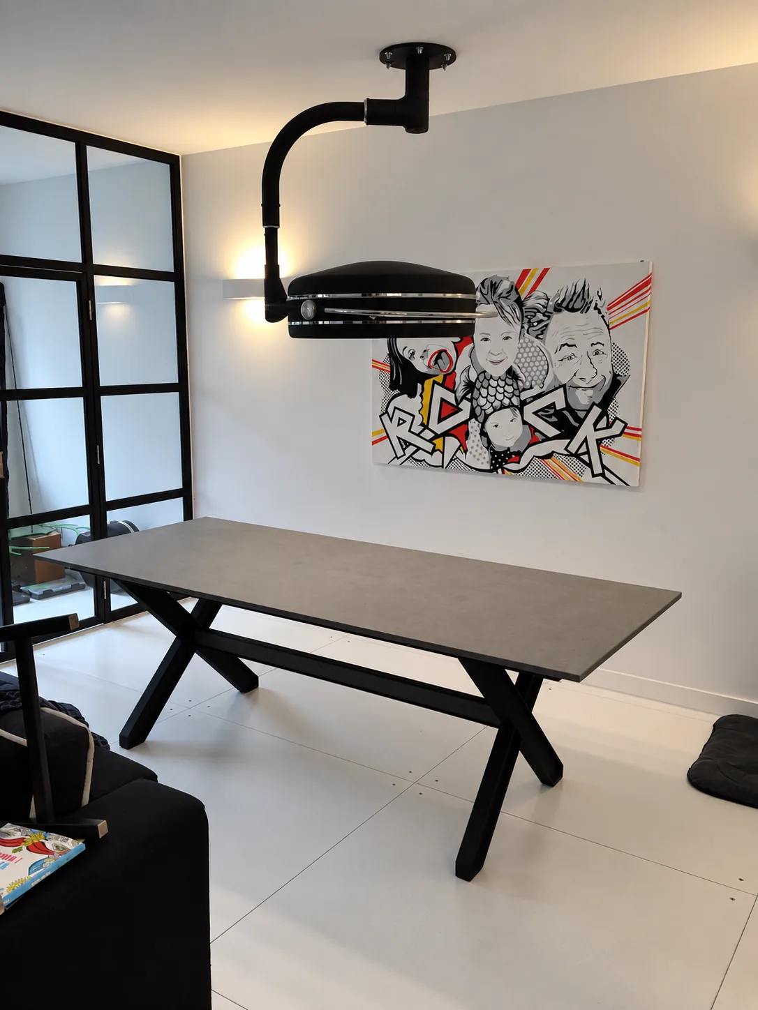 Stół z granitowym blatem na charakterystycznej, czarnej stalowej konstrukcji zestawiono z personalizowaną lampą chirurgiczną.